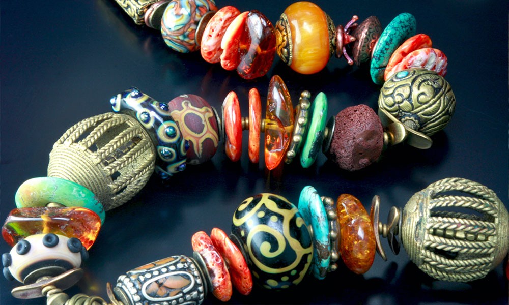 Mixed-media Necklace by Mountain-Robbins Studio :: Glass beads, metal charms, African brass, Tibetan silver, and Baltic amber.